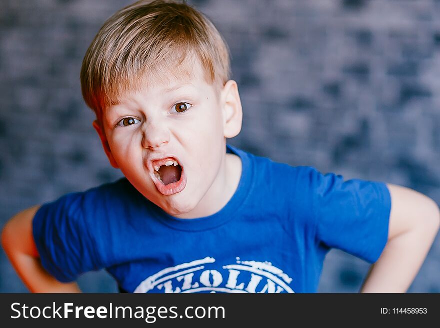 Five year old boy grimaces and open his mouth in front of the camera. Five year old boy grimaces and open his mouth in front of the camera