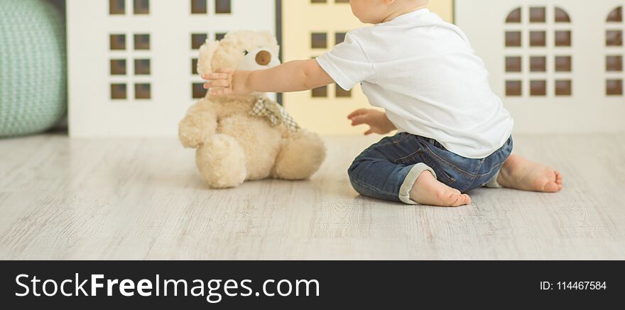 Litle boy sits on the floor at bedroom