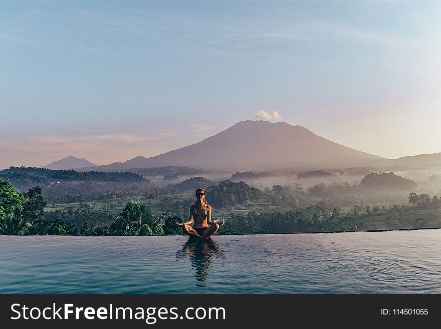 Series traveling girl in Asia. beautiful girl with long dark hair in swimming suit in beautiful nature place in Bali, posing near swimming pool with volcano Agung view. Series traveling girl in Asia. beautiful girl with long dark hair in swimming suit in beautiful nature place in Bali, posing near swimming pool with volcano Agung view