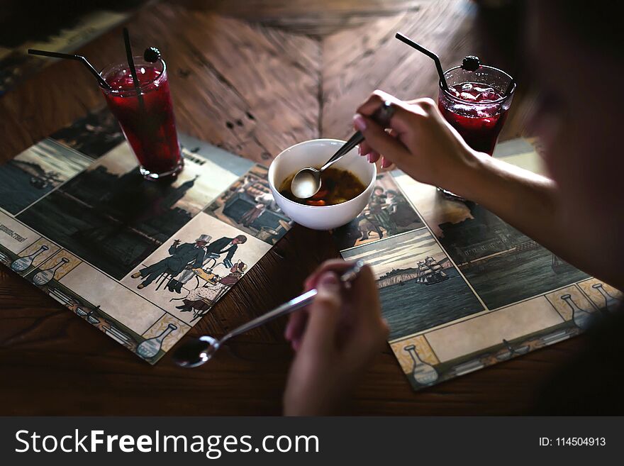 A joint breakfast of two lovers with two cocktails and a white bowl of soup