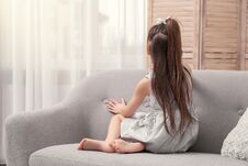 Lonely Little Girl Sitting On Sofa Near Window Indoors Royalty Free Stock Images