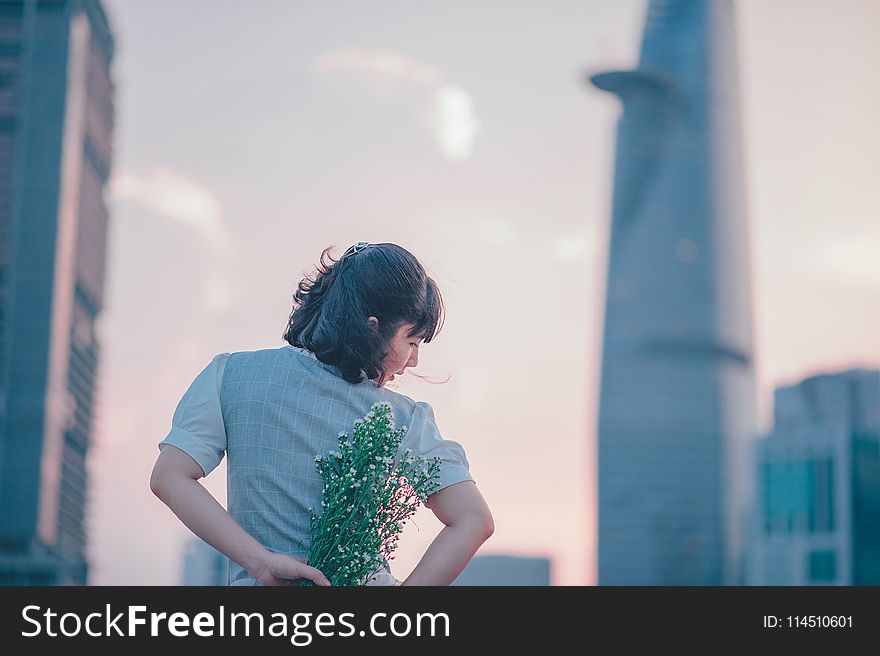 Selective Focus Photo of Woman Holding White Flower