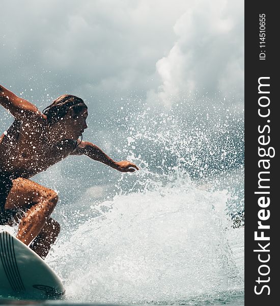 Man Riding White Surfboard