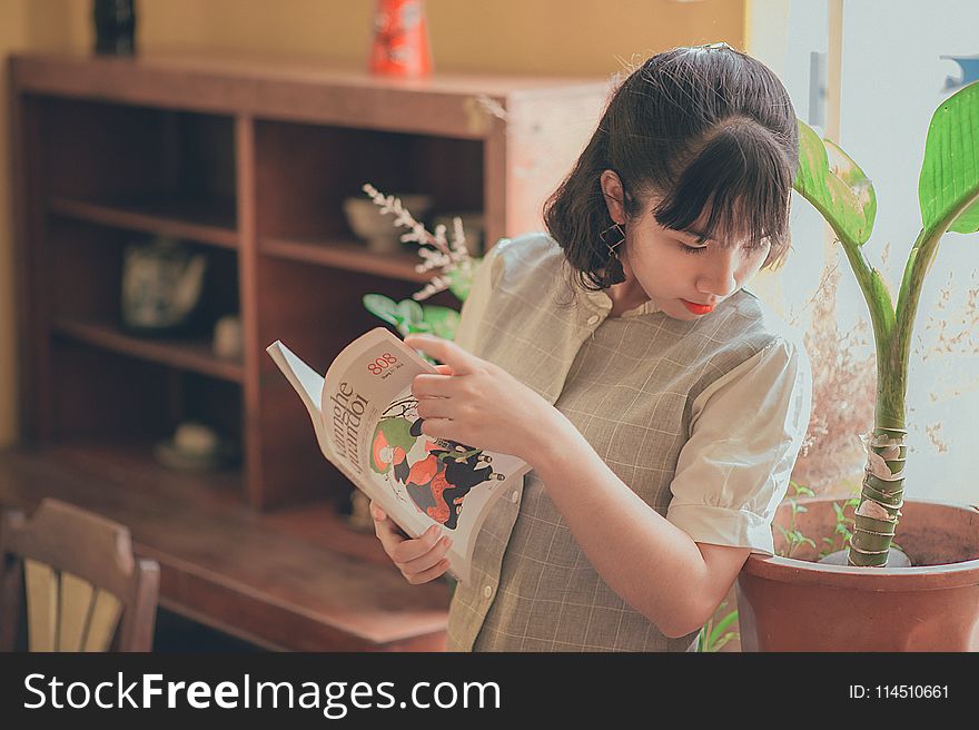 Woman In Grey Button-up Short-sleeved Top Holding Book