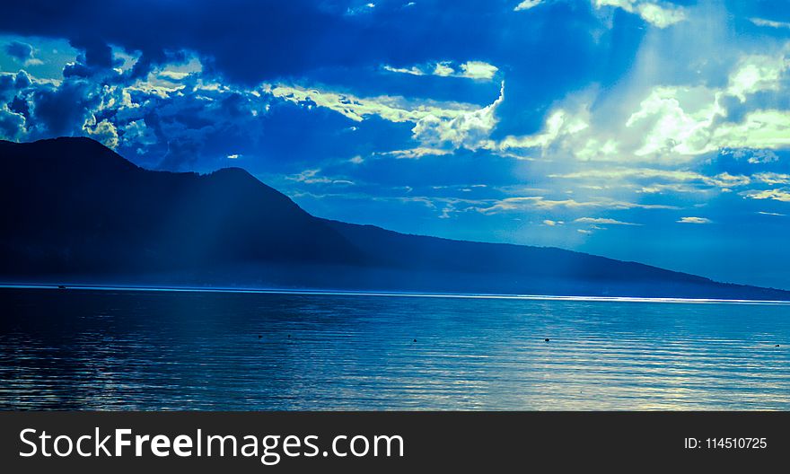 Silhouette of Mountain Near Water at Daytime