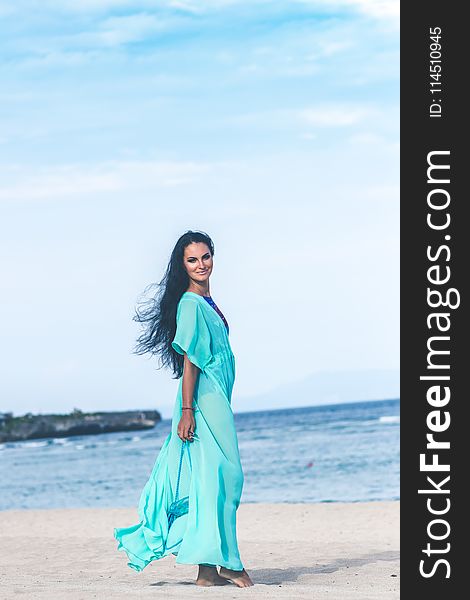 Woman In Teal Dress On Seashore