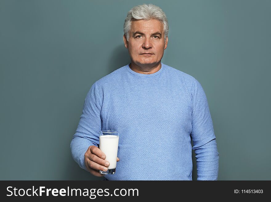 Mature man with dairy allergy holding glass of milk