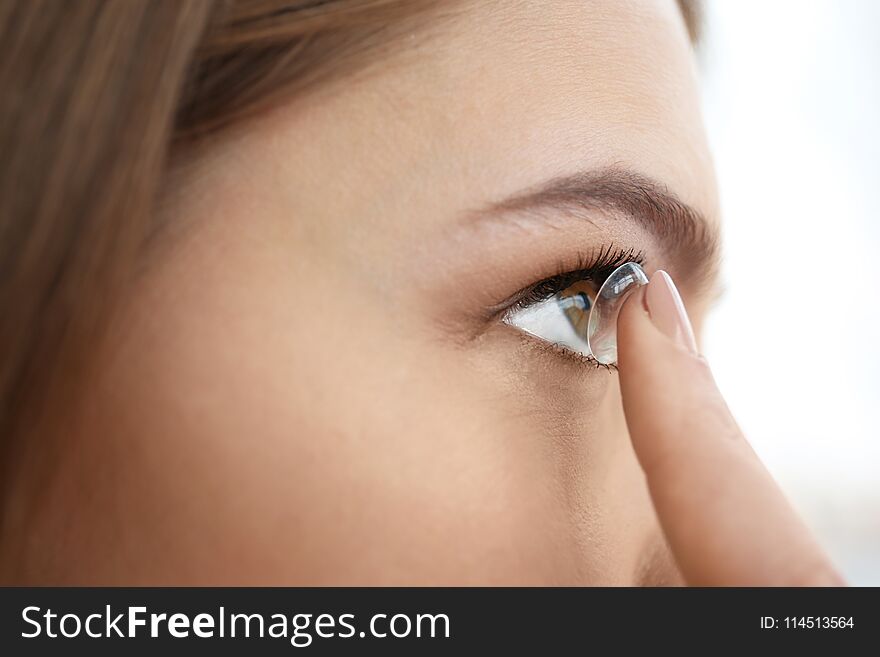 Young Woman Putting Contact Lens In Her Eye,
