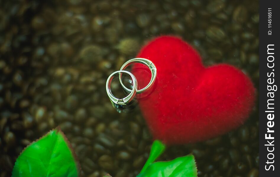 Background Silver Ring Couples Are Placed On Red Hearts And Coffee.background Noise And Blurred