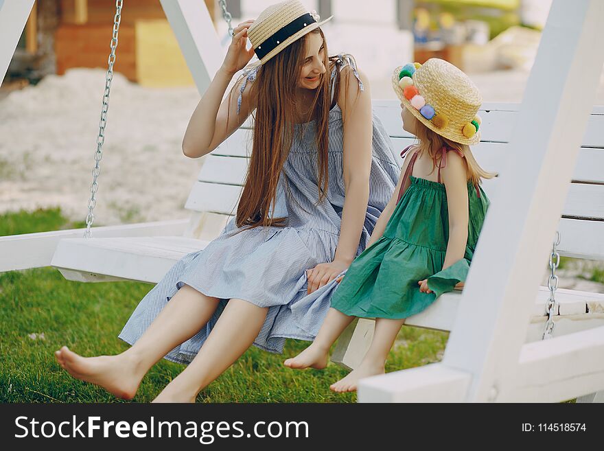 A beautiful young mother plays on the beach with her little daughter. A beautiful young mother plays on the beach with her little daughter