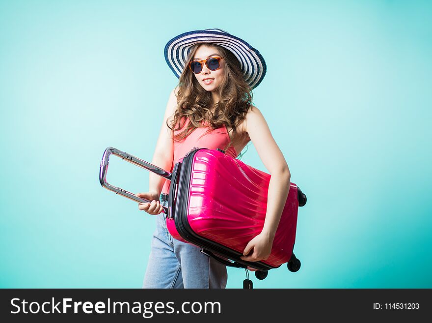 Woman traveler with suitcase on color background