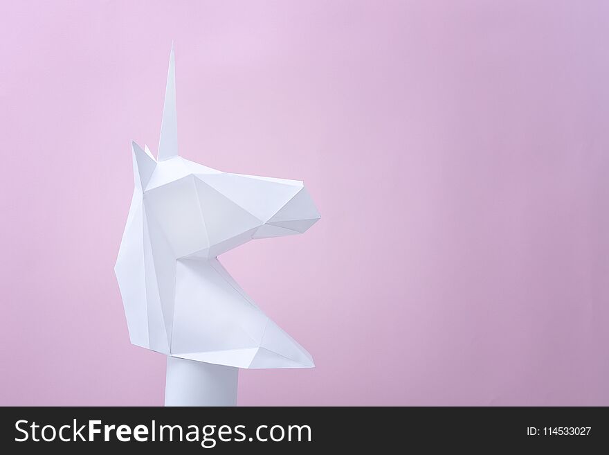 White paper unicorn on a pink background. Space for text.