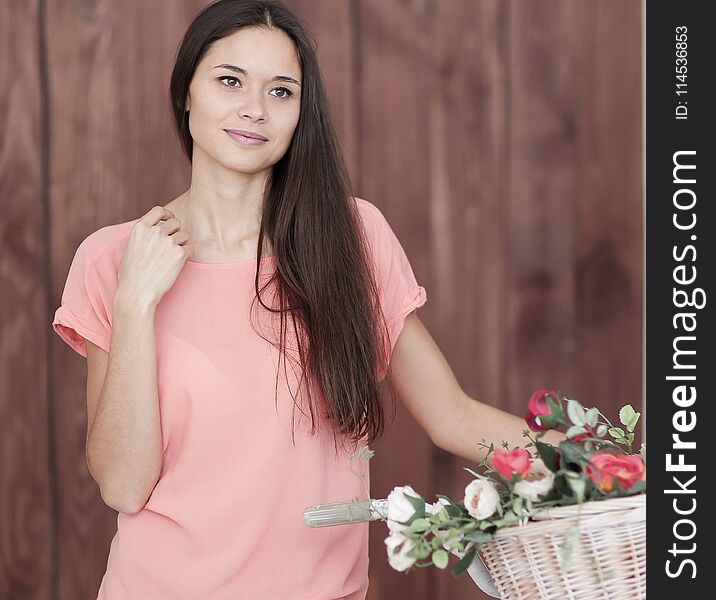 Portrait of a young woman with Bicycle and spring flowers in a basket