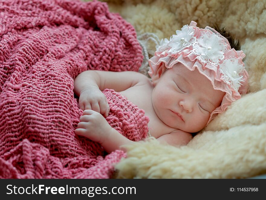 born baby girl is sleeping on fur blanket