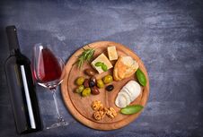 Bottle And Glass Of Wine With Cheese, Olives, Bread, Nuts And Basil On Dark Background. Royalty Free Stock Images