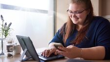 Bigger Girl Smiling While Checking Her Cellphone At A Cafe Stock Photography Bigger Girl Smiling While Checking Her Cellphone At A Cafe Stock Photography