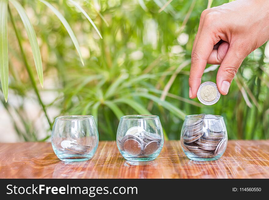 Hand of female putting coins in jar with money stack step growing growth saving money.Money Saving Ideas