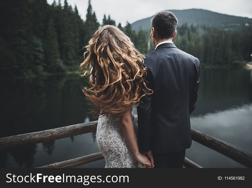 Beautiful wedding couple near lake with perfect view