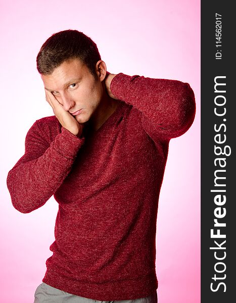 Handsome man in sweater. Pink background. Spring. and blossom