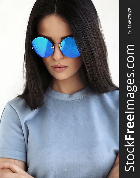 Fashion interior photo of beautiful young woman with long dark hair in elegant cozy clothes and sunglasses. Fashion interior photo of beautiful young woman with long dark hair in elegant cozy clothes and sunglasses