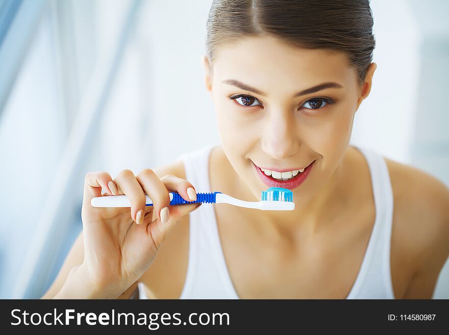 Beautiful Smiling Woman Brushing Healthy White Teeth With Brush.
