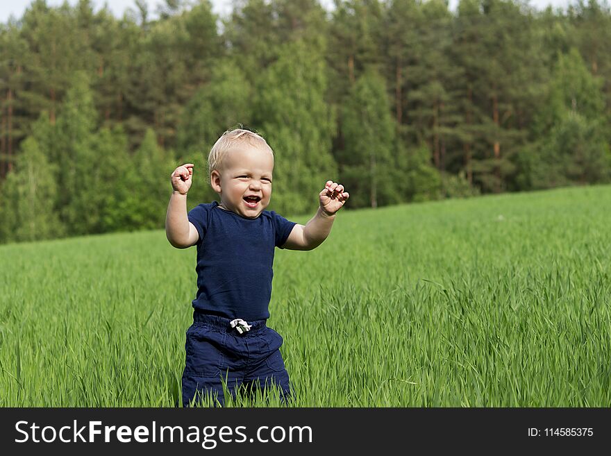 Happiness Baby boy sitting on the grass in field