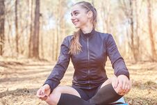 Sporty Girl In Lotus Pose Smiling In The Woods Royalty Free Stock Photography