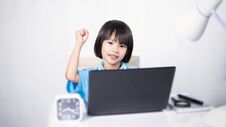Cute Child Thinking And Typing Laptop. Stock Images