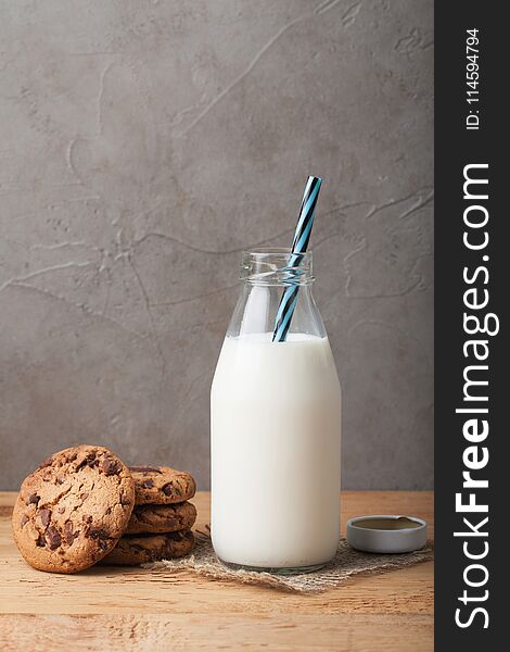 Bottle With Milk And Chocolate Chip Cookies On Dark Background With Copy Space