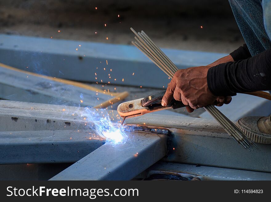 Asian Worker Making Sparks While Welding Steel