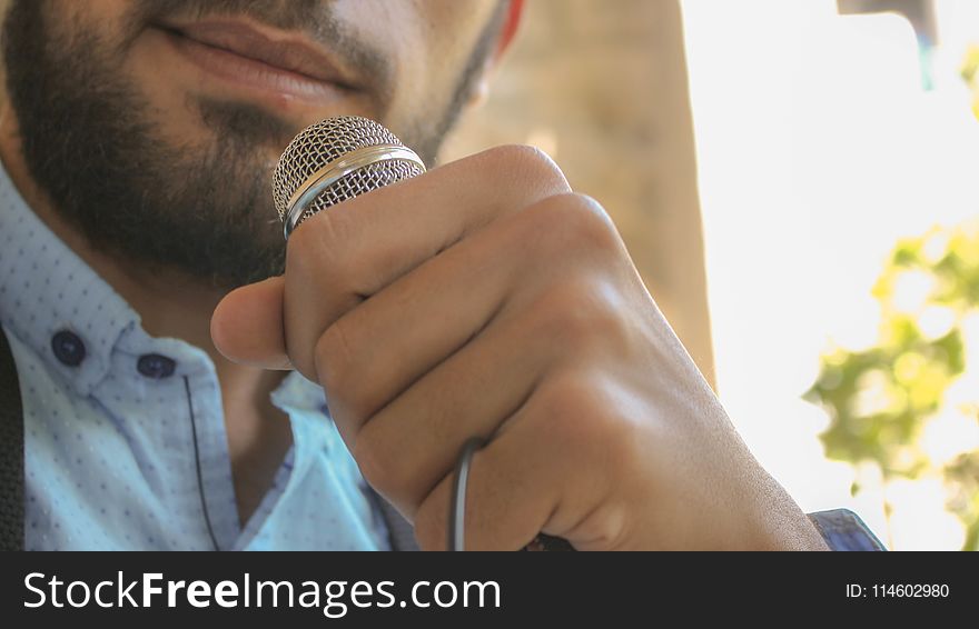 Close-up Photo of Man Holding Microphone
