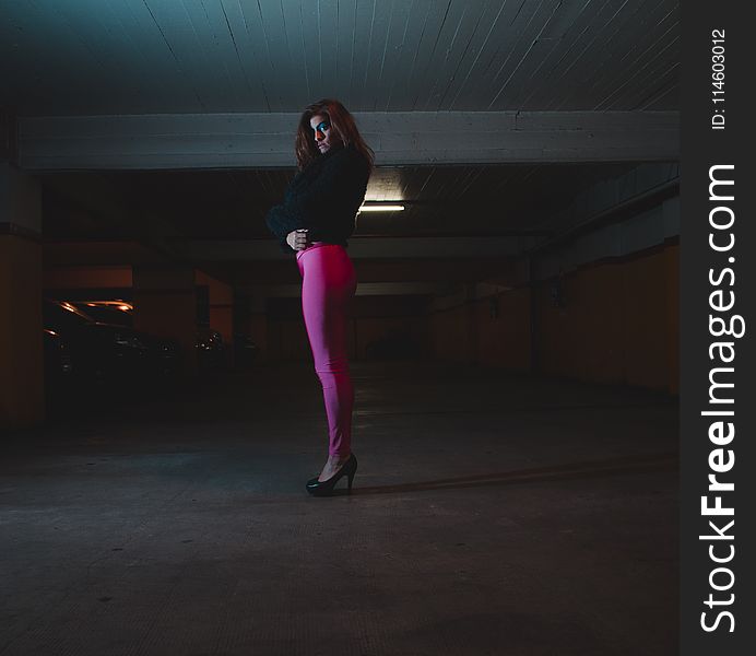 Photo of Woman Wearing Black Shirt and Pink Leggings in Parking Area