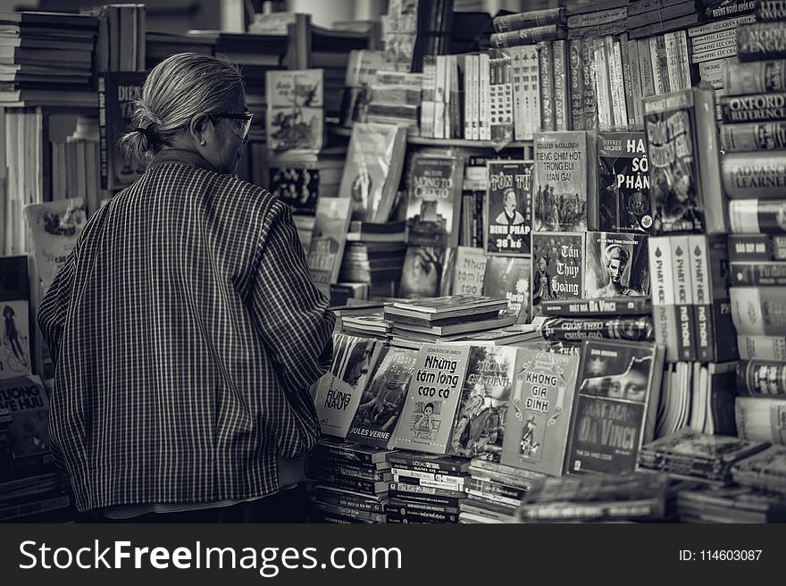 Grayscale Photography of Woman Looking at the Books