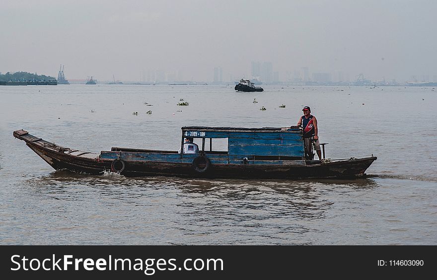 Photo of Man on Wooden Boat