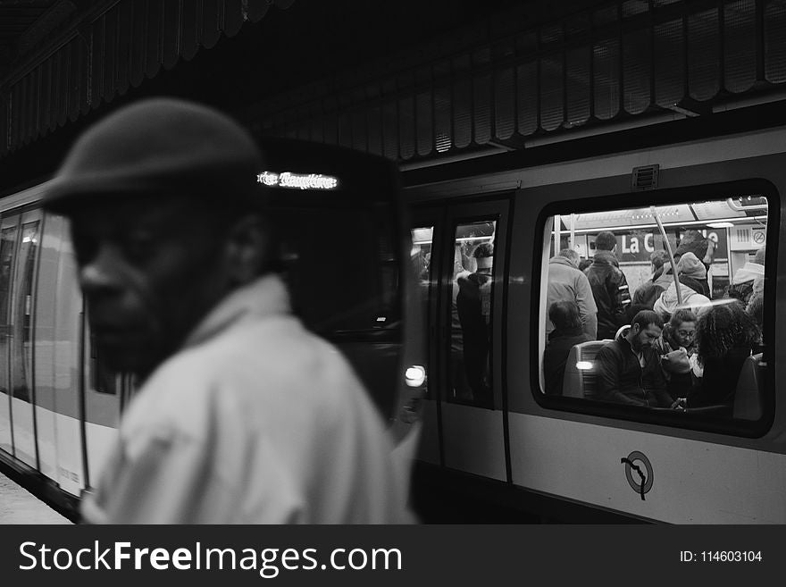 Grayscale Photo of People Inside Train