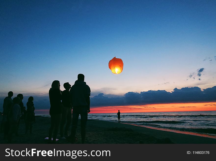 Silhouette Of People By The Sea.