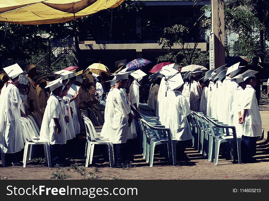 Children Wearing White Academic Gown during Graduation Ceremony at Daytime