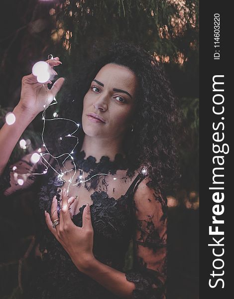 Photography of a Woman Holding String Lights