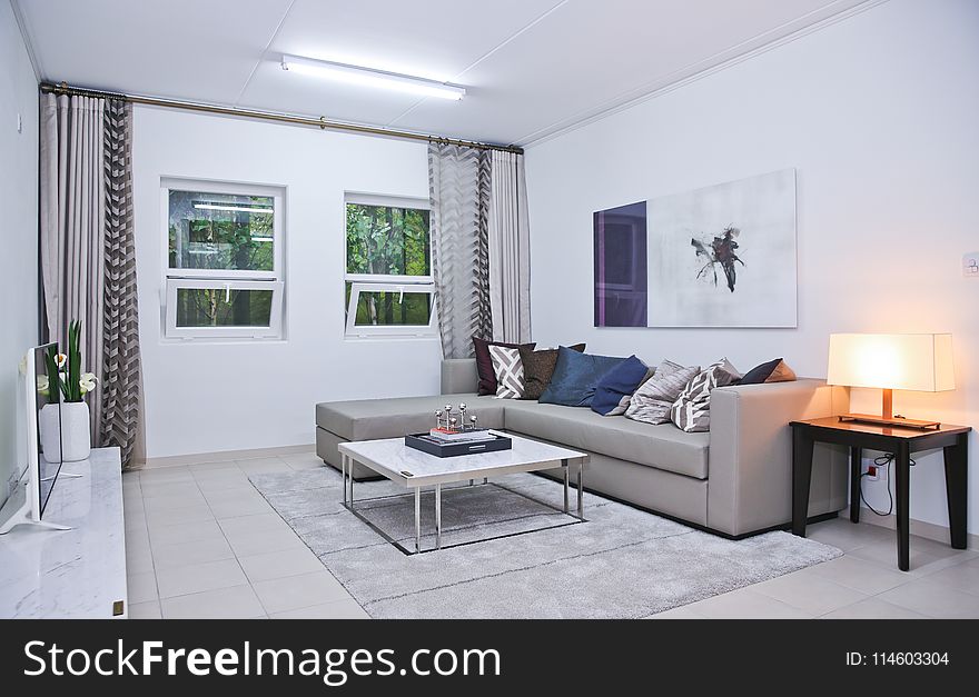 Gray Fabric L-shape Sofa And Assorted-color Throw Pillows In White Living Room