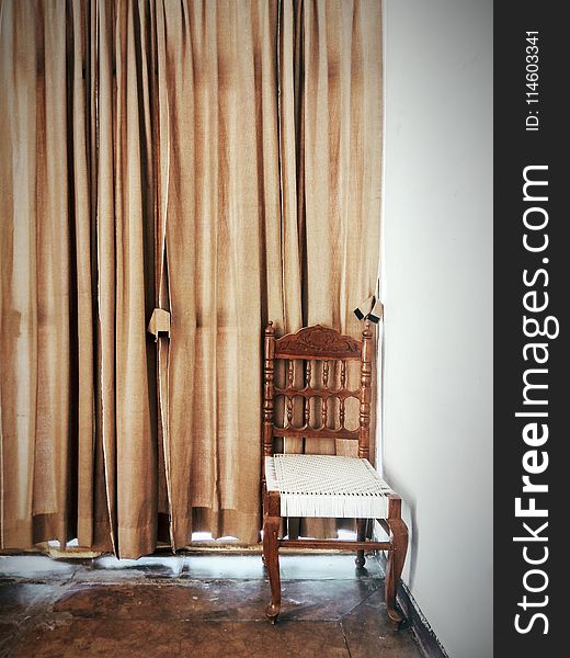 Brown And White Wooden Chair Beside A Brown Window Curtain