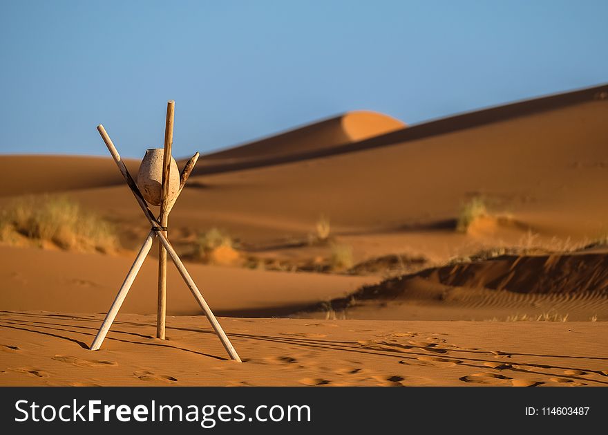 Brown Stone On Tripod Sticks At A Desert