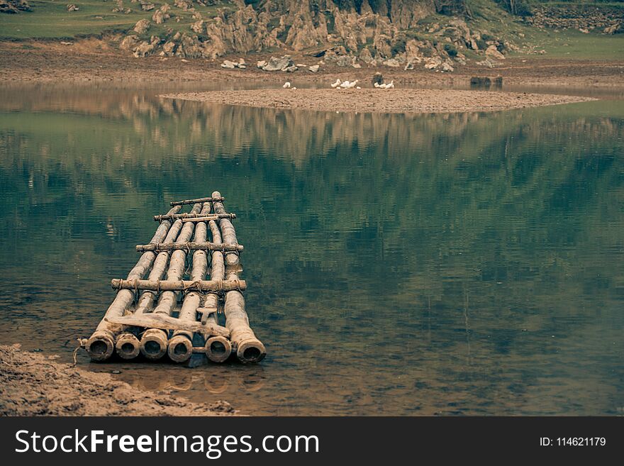 A Lone Raft Awaits A Villager On A River In Vietnam