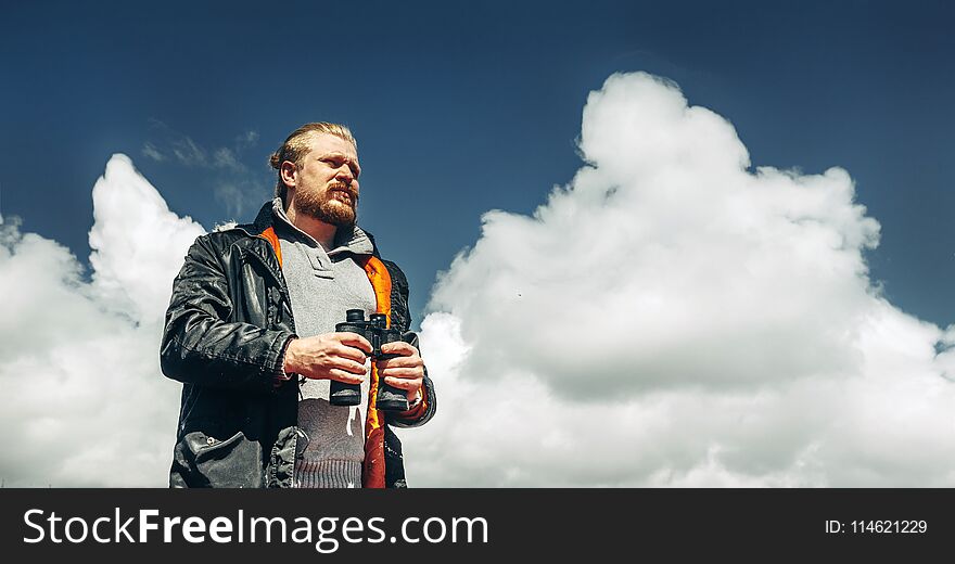 Travel Search Concept. Hiking Man With Beard Holds Binoculars In