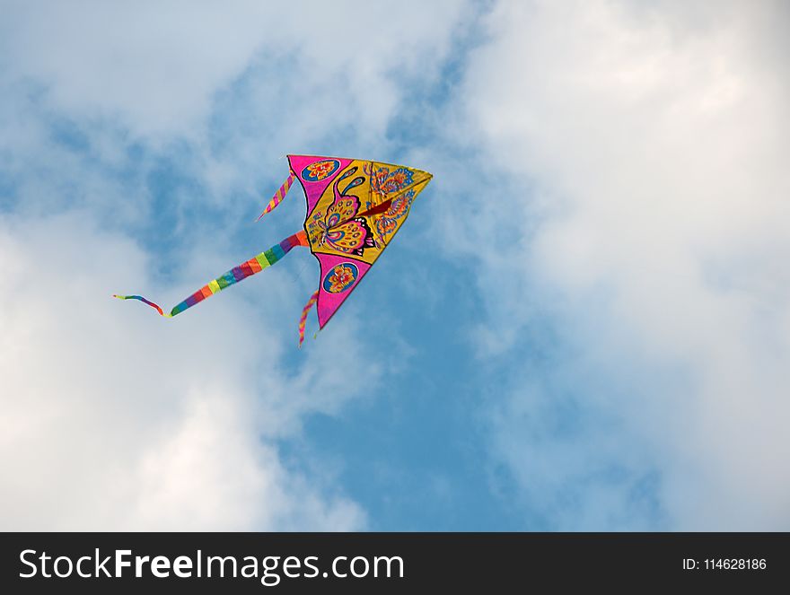 A big colorful kite in the blue sky with clouds. A big colorful kite in the blue sky with clouds