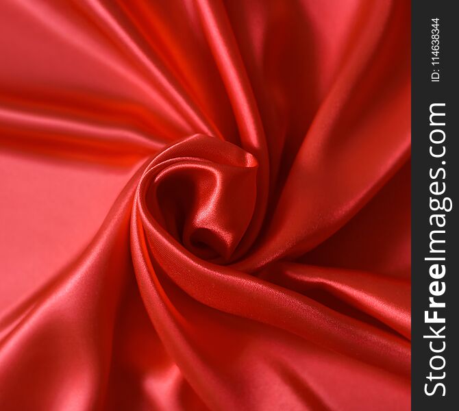 Close Up Of Ripples In Shape Of Rose Flower On Red Silk Fabric.