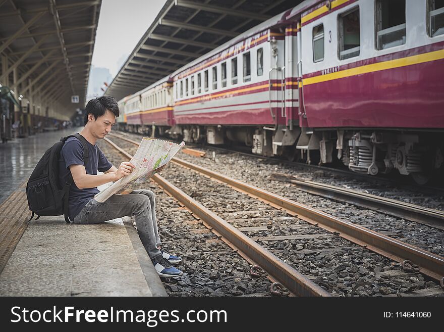 Tourist searching route on map at train station, travel concept. Tourist searching route on map at train station, travel concept
