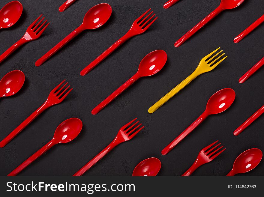 Many white plasic forks and a red one on violet background with copy space, top view. Be brave and different, leadership concept. Many white plasic forks and a red one on violet background with copy space, top view. Be brave and different, leadership concept
