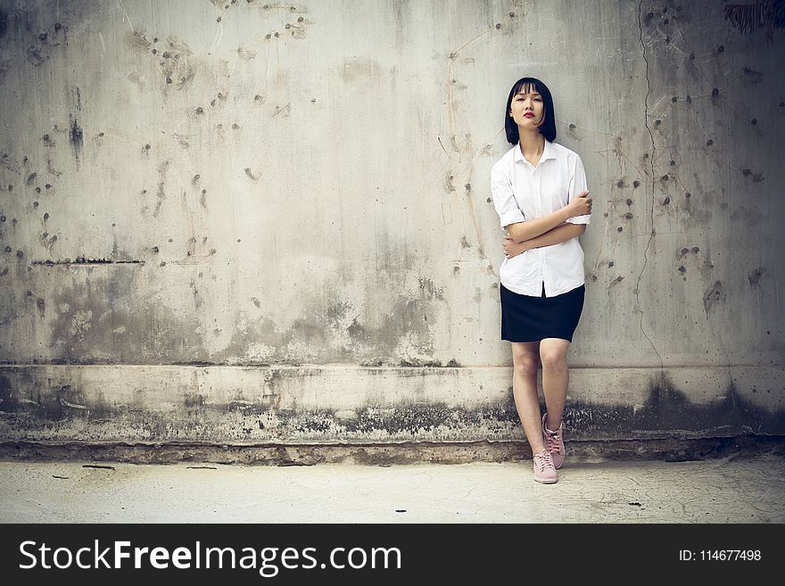 Woman Standing Next To A Wall