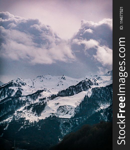 Photography Of Snow Capped Mountain Under Cloudy Sky