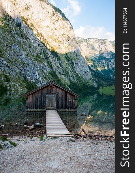 Brown Wooden Dock Near Rocky Cliff